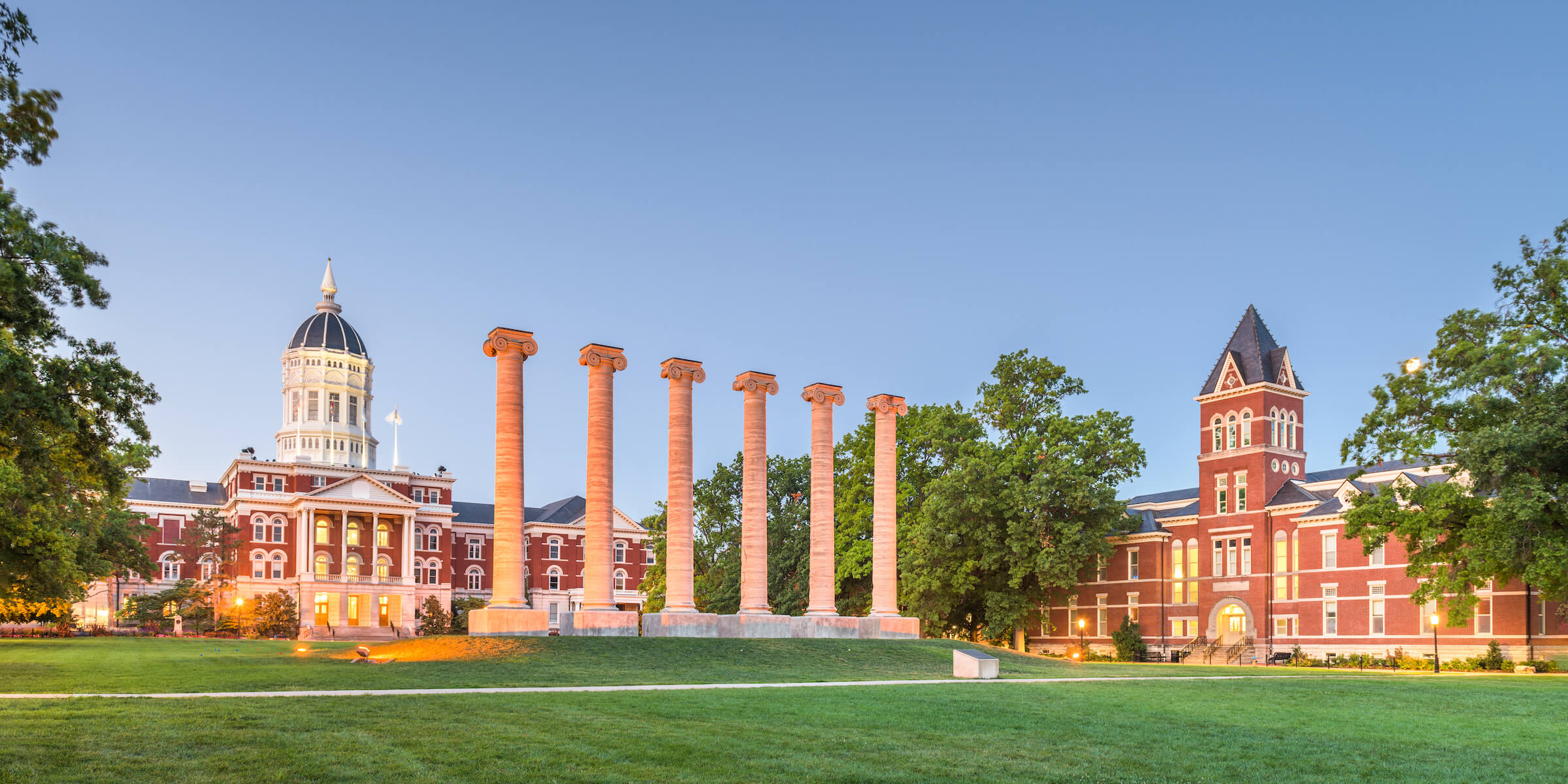 a sunny field outside of a college campus