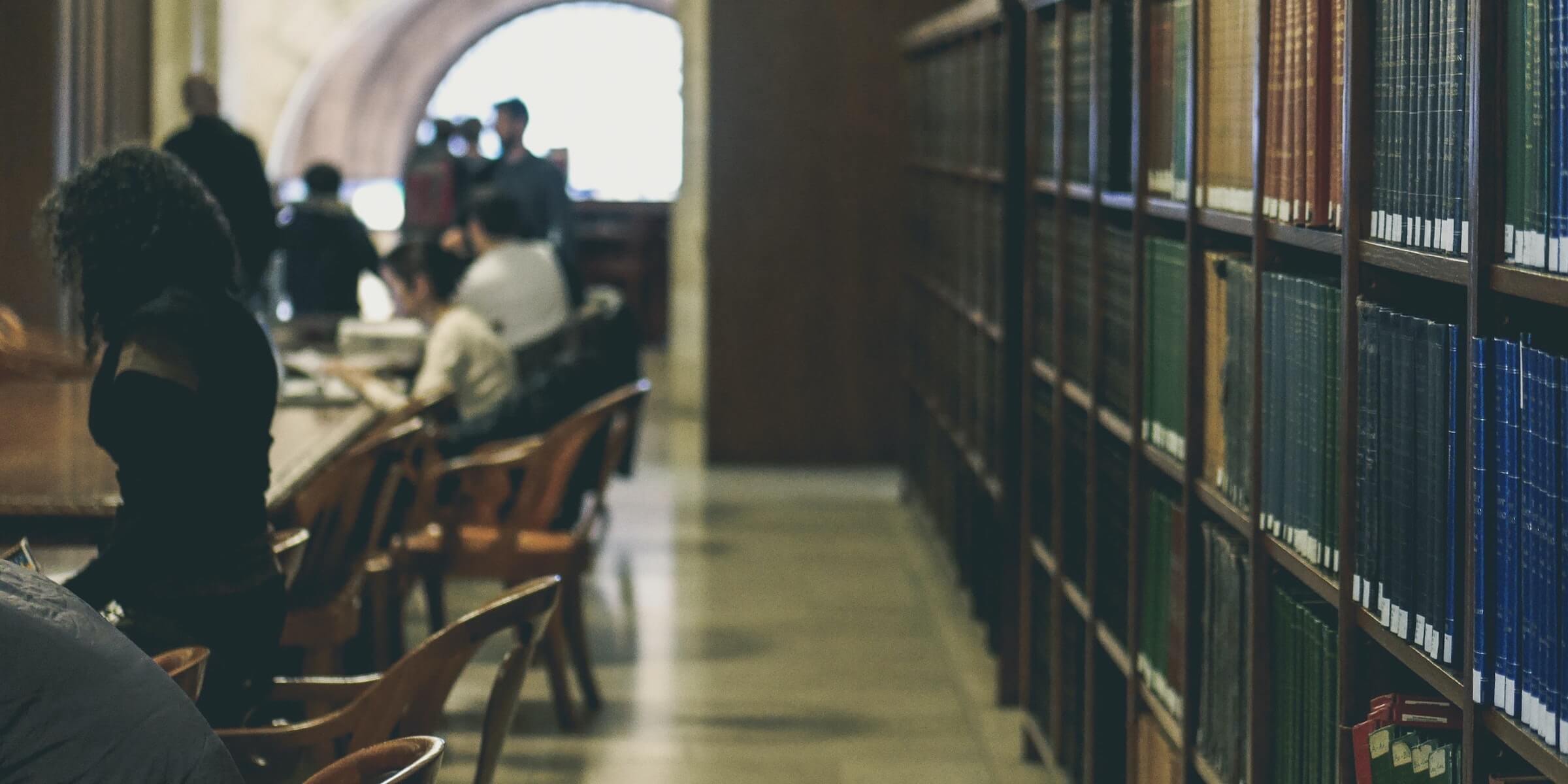 students at a table inside a library