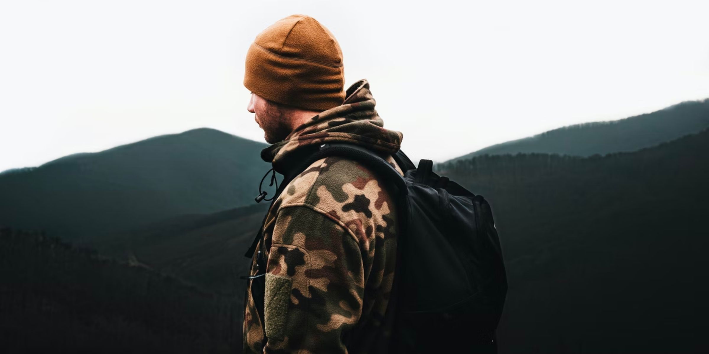 a student in a cameo jacket standing on a mountain