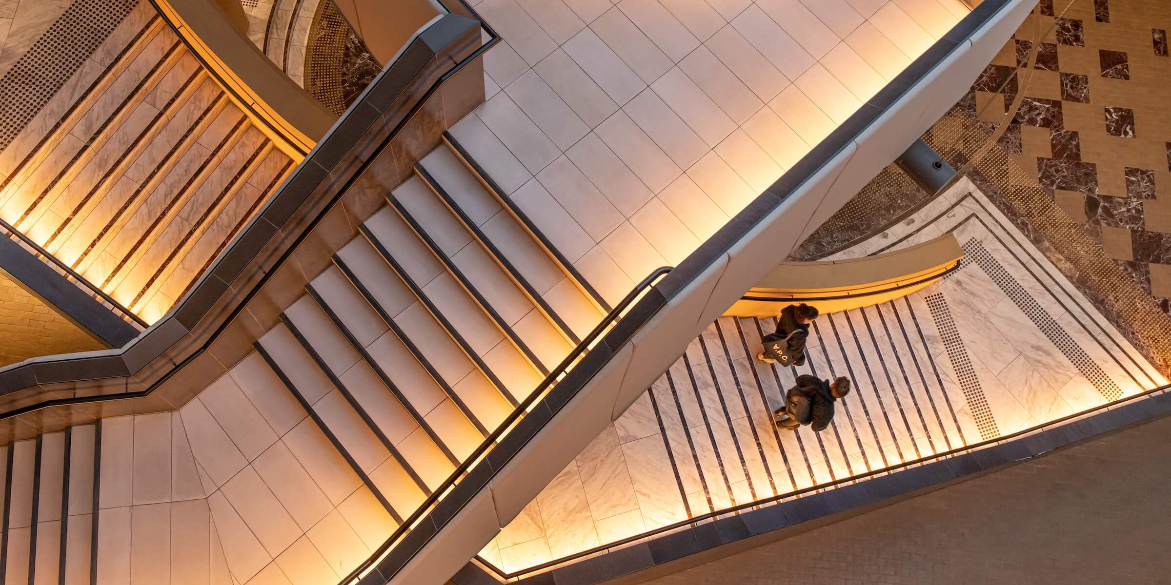 Two people walking down stairs together 