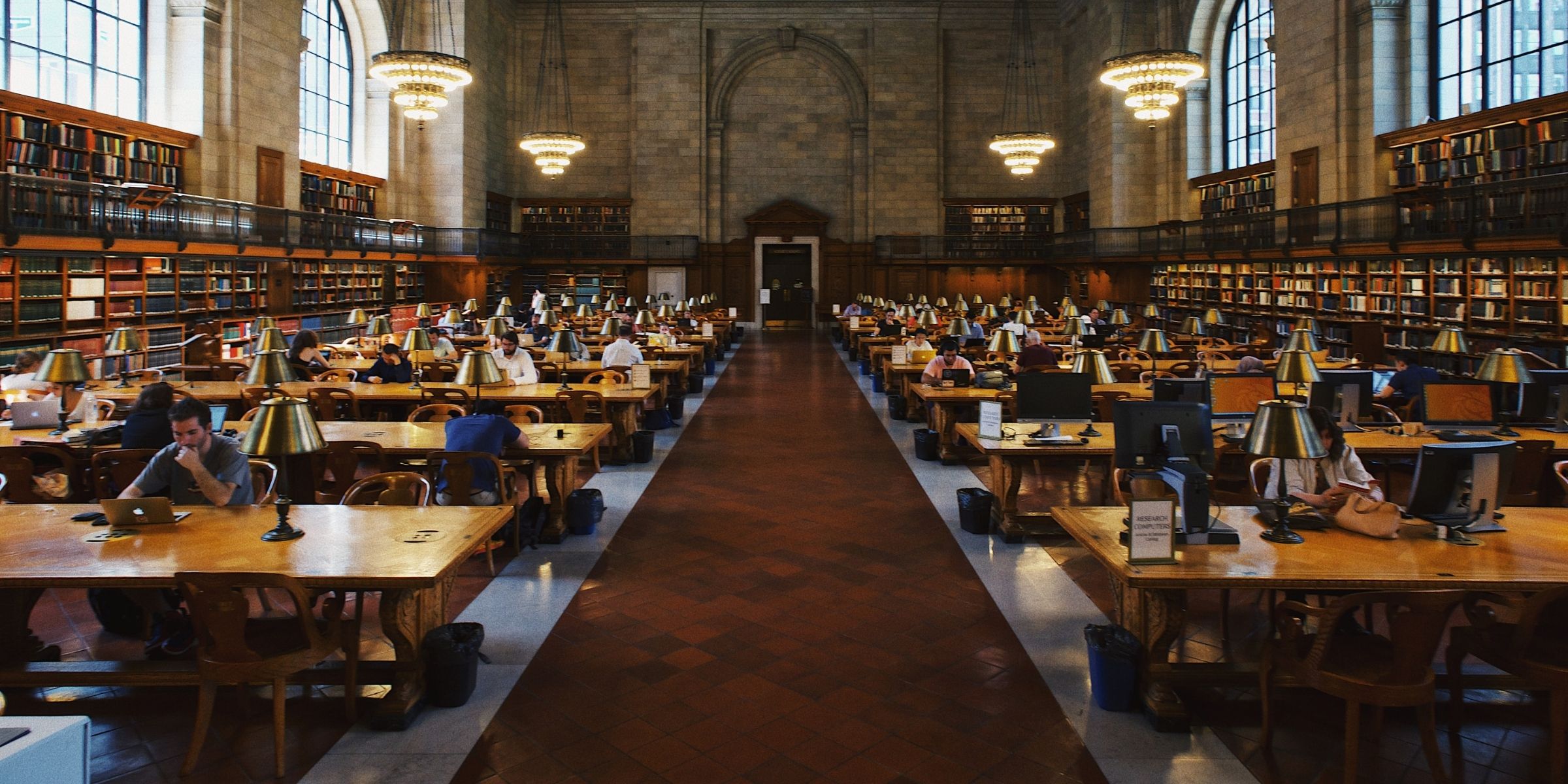 Dozens of students sitting at tables in a large library