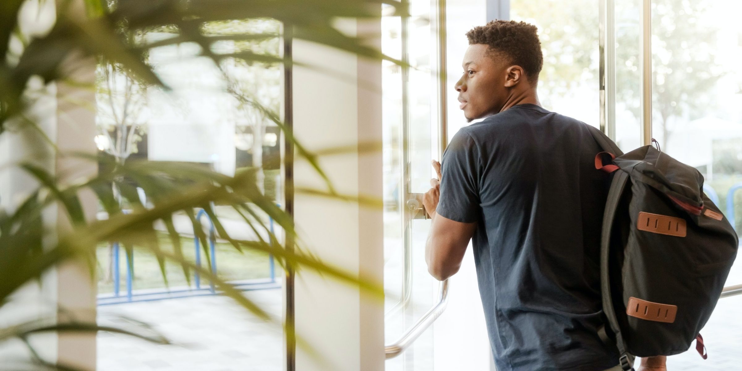 a student with a backpack exiting a campus building