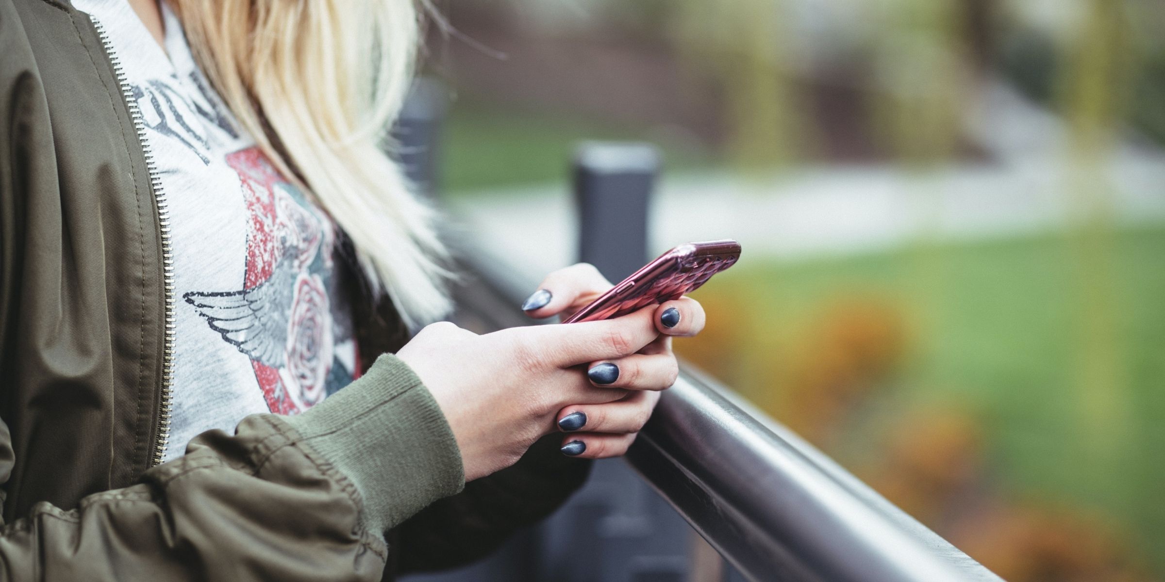 a student texting on a cell phone outdoors