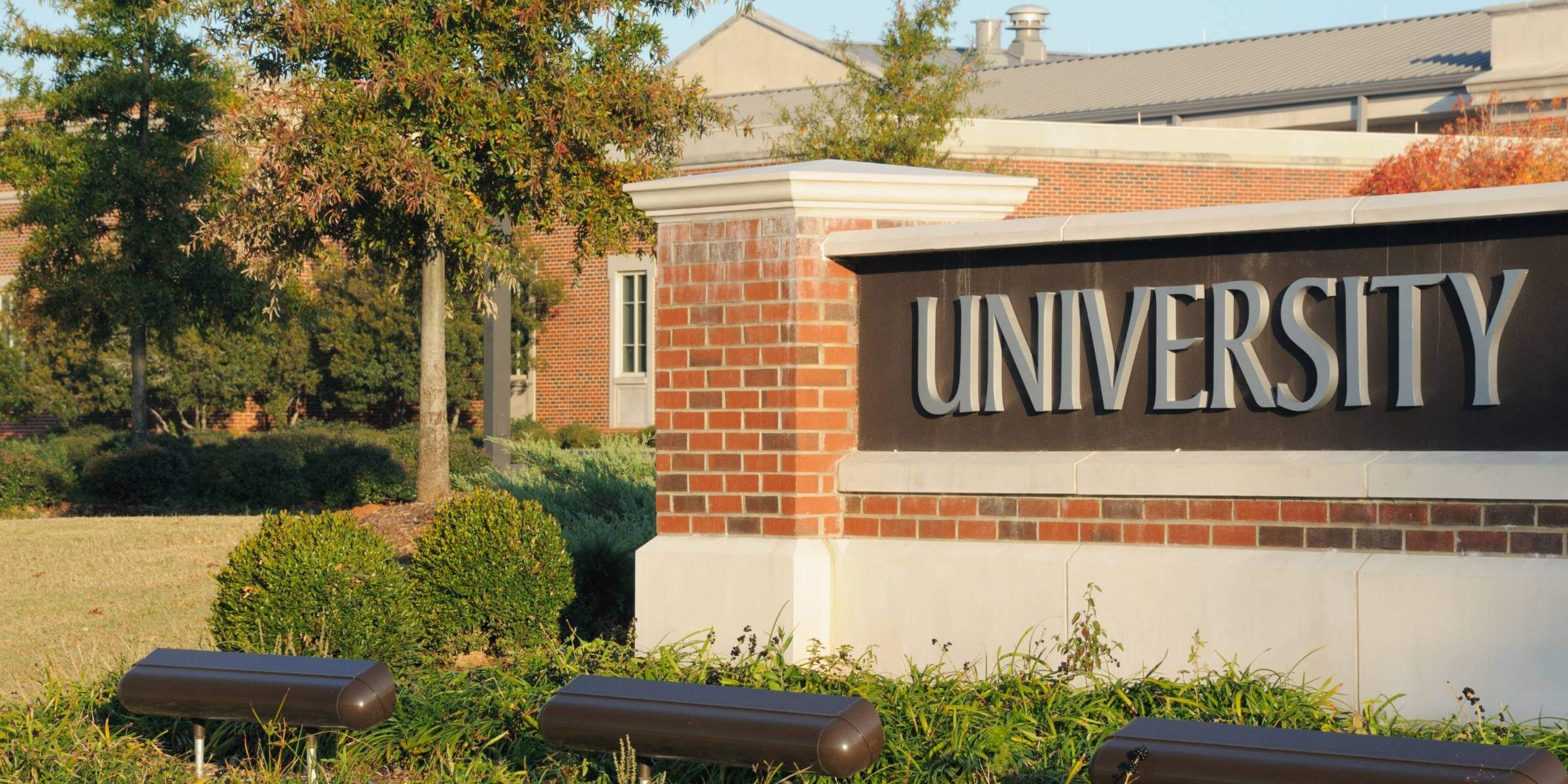 an outdoor campus sign that says "university"