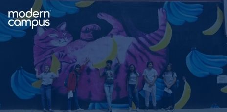 six Peak Education students smiling in front of a huge mural of a bright pink cat