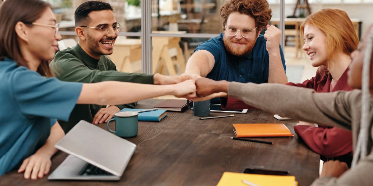 group-of-students-joining-hands-in-the-center