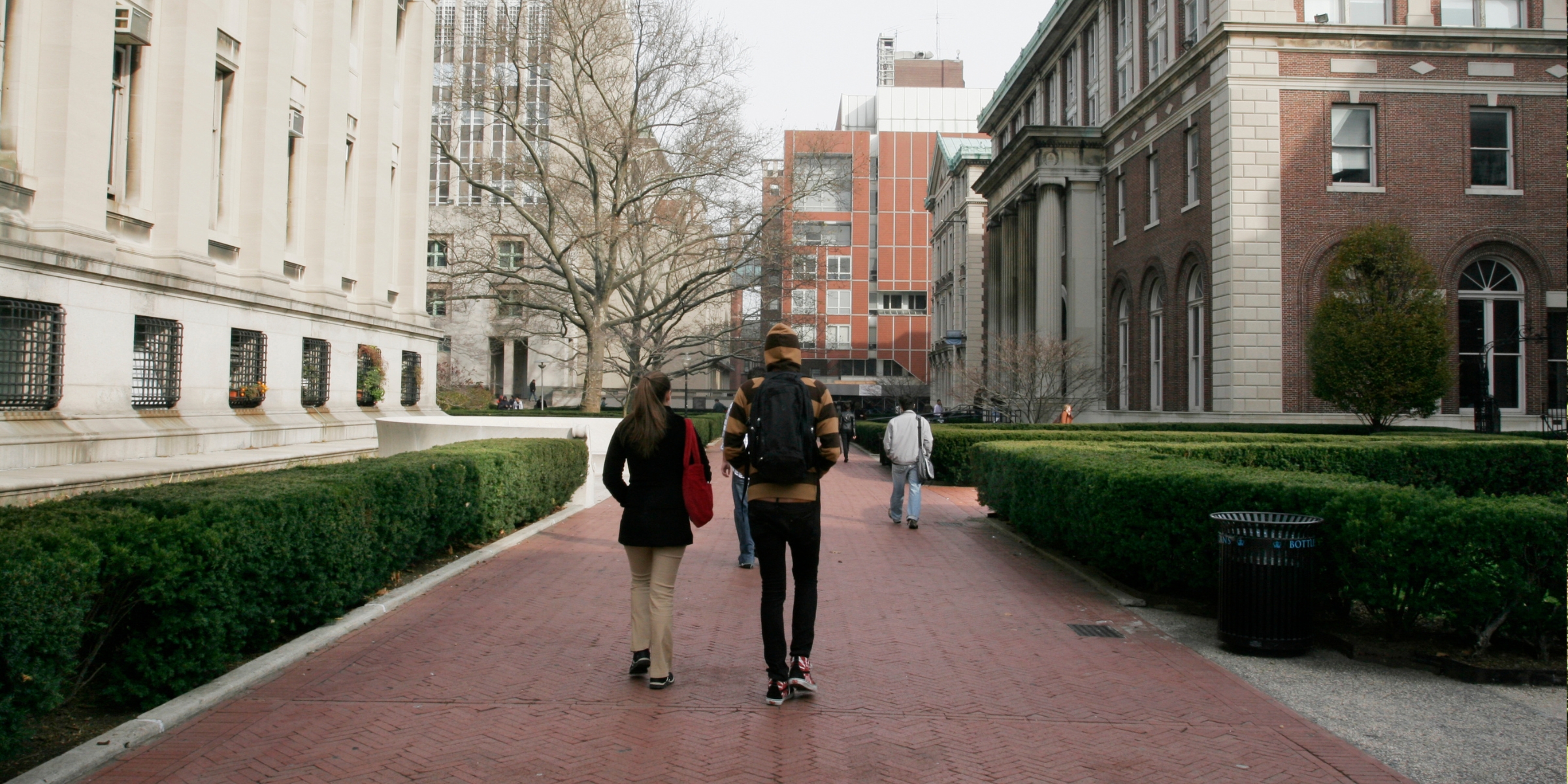 two students walking between buildings of an urban campus